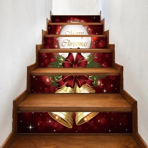 Detail of red Merry Christmas stair stickers with golden bells and silk bows on wood steps