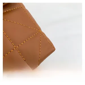 Vue macro de la texture en cuir matelassé marron et des coutures de qualité sur le sac
