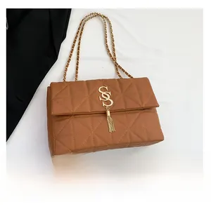 Vue détaillée du sac matelassé marron avec pompon doré et bandoulière chaîne en comparaison
