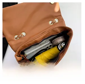 Vue intérieure du sac matelassé marron avec parapluie, téléphone et cosmétiques