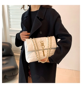 Détail du sac à bandoulière matelassé blanc avec ferrures dorées SS et pompon élégant