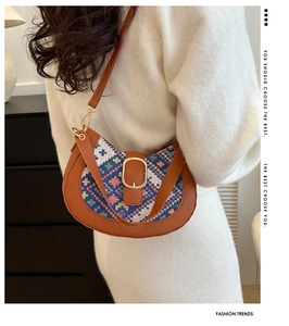 Close-up of bohemian hobo bag with colorful geometric patterns and leather trim on a model