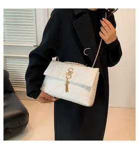 Sac bandoulière blanc matelassé avec logo doré, pompon et bandoulière en chaîne