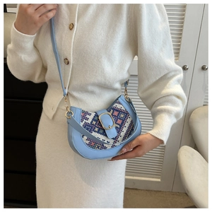 Detail of light blue crescent bag with geometric ethnic fabric and gold buckle clasp