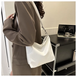Gros plan d'un sac hobo blanc minimaliste en cuir mat pour les trajets quotidiens
