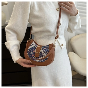 Detail of half-moon crossbody bag with retro woven pattern and gold metal buckle