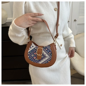 Detail of national style half-moon bag featuring woven geometric patterns and golden buckle