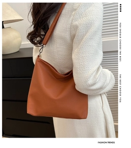 Close-up of caramel brown lychee leather handbag texture and gunmetal hardware hook