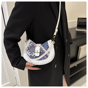 Detail shot of a white saddle bag with blue-pink geometric patterns worn by a model
