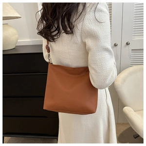 Brown faux leather bucket bag detail with lychee texture and adjustable shoulder strap