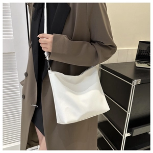 Detail of white pebbled leather shoulder bag showing the textured finish and strap