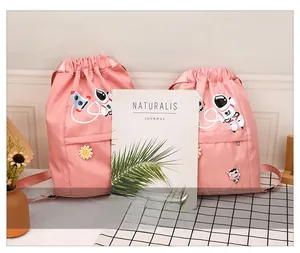 Size comparison of pink waterproof nylon drawstring bags with cute astronaut embroidery