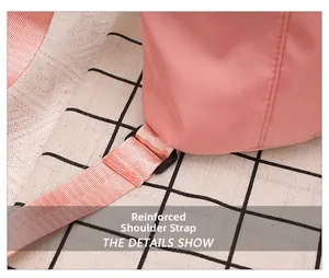 Close-up of reinforced shoulder strap stitching and plastic buckle on pink nylon bag