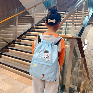 Detail of light blue nylon kids drawstring bag with cartoon astronaut and sunflower patch