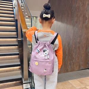 Detail of purple nylon kids drawstring backpack with astronaut embroidery and front zipper