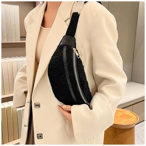 Close-up of black fuzzy lamb wool fanny pack worn over a beige blazer for autumn style