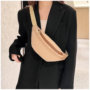 Detail of beige faux shearling belt bag featuring adjustable strap and metal zipper