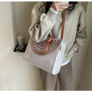 Detail of canvas tote bag with geometric pattern and brown leather straps