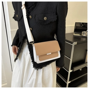 Brown and white crossbody bag with geometric wide strap shown from a side view