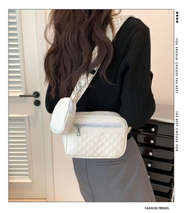Detail of quilted white crossbody bag with wide patterned strap and matching mini pouch