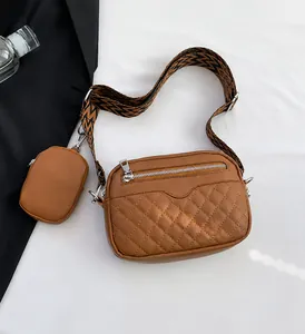 Detail view of brown quilted crossbody bag with matching coin purse and woven strap