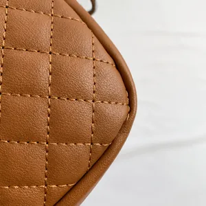Macro shot of brown leather shoulder bag with classic quilted diamond stitching texture