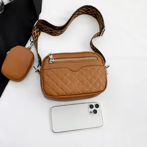 Brown quilted crossbody bag with patterned strap and small round pouch accessory