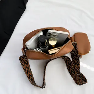 Internal view of brown leather bag with geometric strap and round coin purse