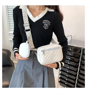 Close-up of white quilted crossbody bag with small round coin purse and woven strap