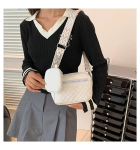 Detail of white quilted crossbody bag with adjustable wide strap and mini coin purse
