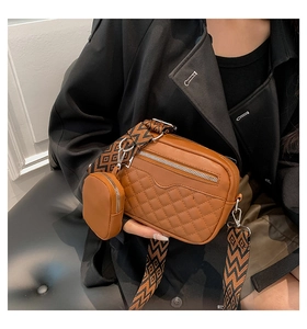 Close-up of brown quilted shoulder bag with geometric wide strap and small round coin purse