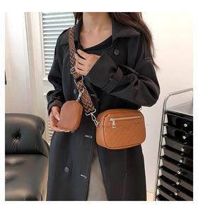 Close-up of brown quilted shoulder bag with patterned strap and small coin purse