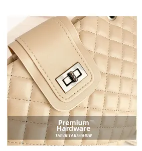 Detail of beige quilted stitching leather bag with a polished metal twist lock closure