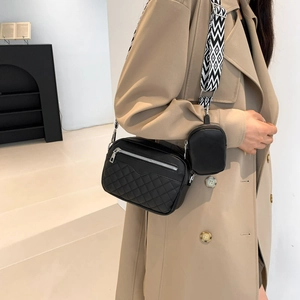 Black quilted crossbody bag with patterned wide strap and small round coin purse pouch