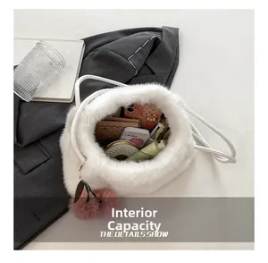 Vista dall'alto dell'ampia capacità interna della borsa a secchiello in peluche bianca con oggetti