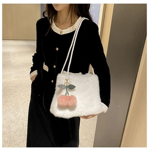 Dettaglio borsa shopper in finta pelliccia bianca con ciondolo ciliegia rosa e manici