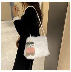 Dettaglio borsa a spalla in peluche bianca con ciondolo a ciliegia rosa e morbida ecopelliccia