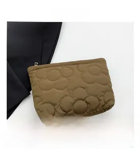 Detail van kaki gewatteerde tas met bloemenstiksel en gouden ritssluiting voor vrouwen