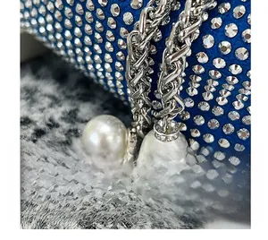 Détail du sac seau en velours bleu avec des strass étincelants et des chaînes argentées