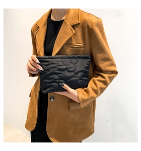 Detail of black cloud-quilted puffy handbag showing texture and sleek zipper closure