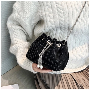 Détail du sac seau en strass noirs avec cordons en perles et bandoulière chaîne argentée