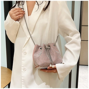 Détail du sac seau rose en strass avec bandoulière chaîne et accents de perles