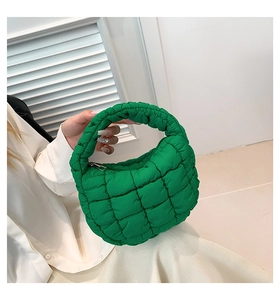 Detail of green quilted cloud bag featuring vibrant nylon fabric and silver zipper