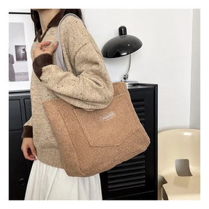 Dettaglio della borsa tote in peluche marrone con texture morbida e logo moda