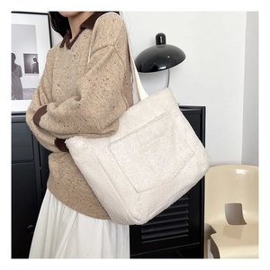 Dettaglio della borsa tote in peluche bianca con etichetta FASHION e morbida trama