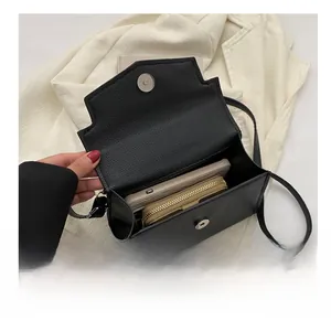 Vue intérieure du sac bandoulière noir montrant le rangement du téléphone et du portefeuille