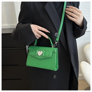 Gros plan du sac à main vert vif en cuir grainé avec fermoir métallique en forme de cœur