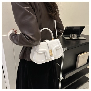 Detailed side view of white faux leather shoulder bag with golden hardware and D-handle