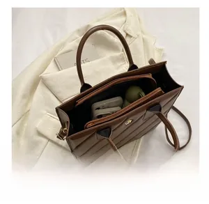 Interior view of brown quilted tote bag showing large capacity with zipper compartment