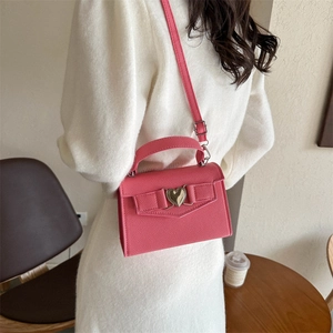 Sac bandoulière rose en cuir grainé avec boucle cœur et nœud sur fond intérieur doux